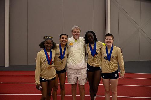 Candis Damste, teammates, and coach posing for a picture.